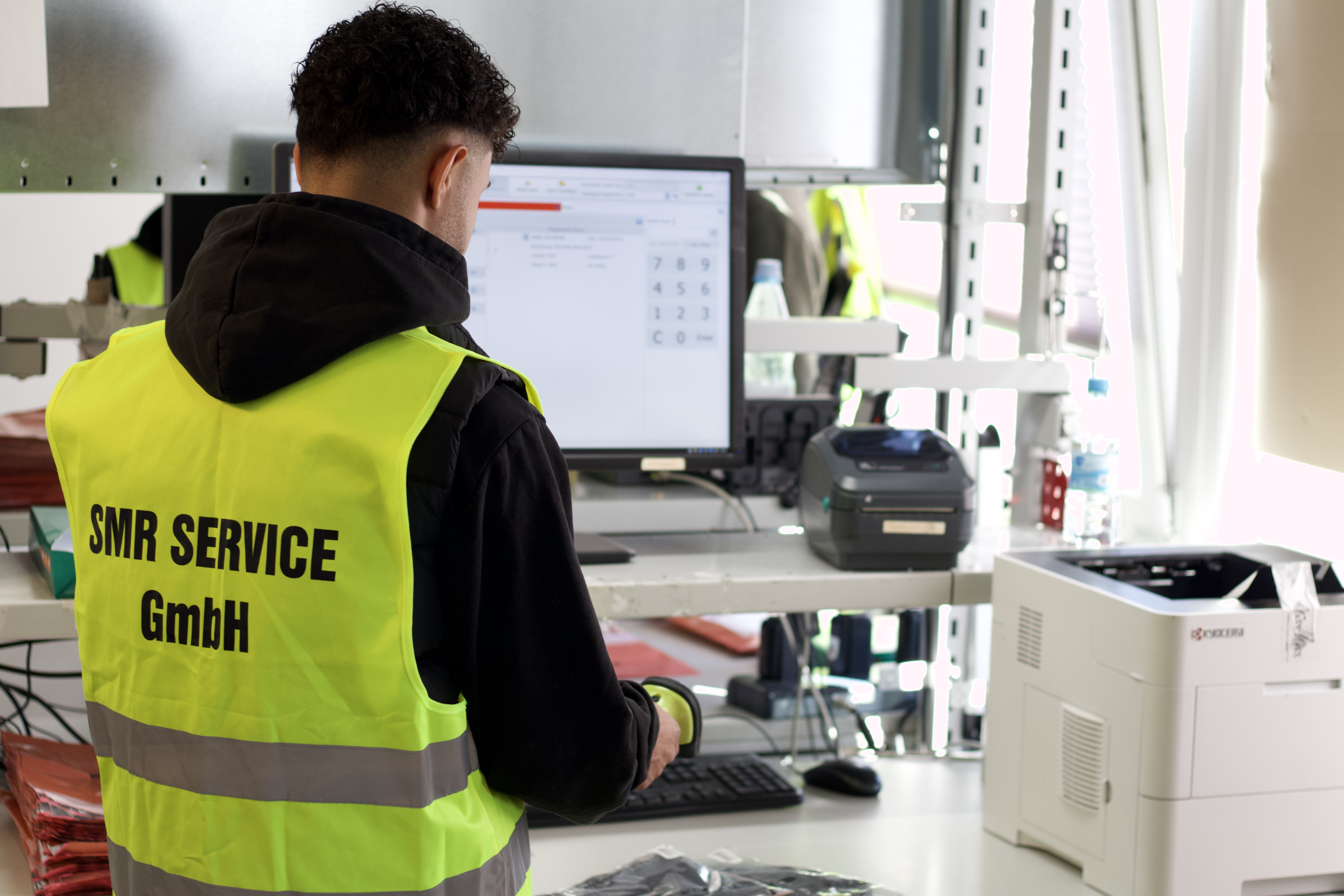 Packplatz mit Mitarbeiter beim Scannen und Etikettieren von Waren im Versandbereich